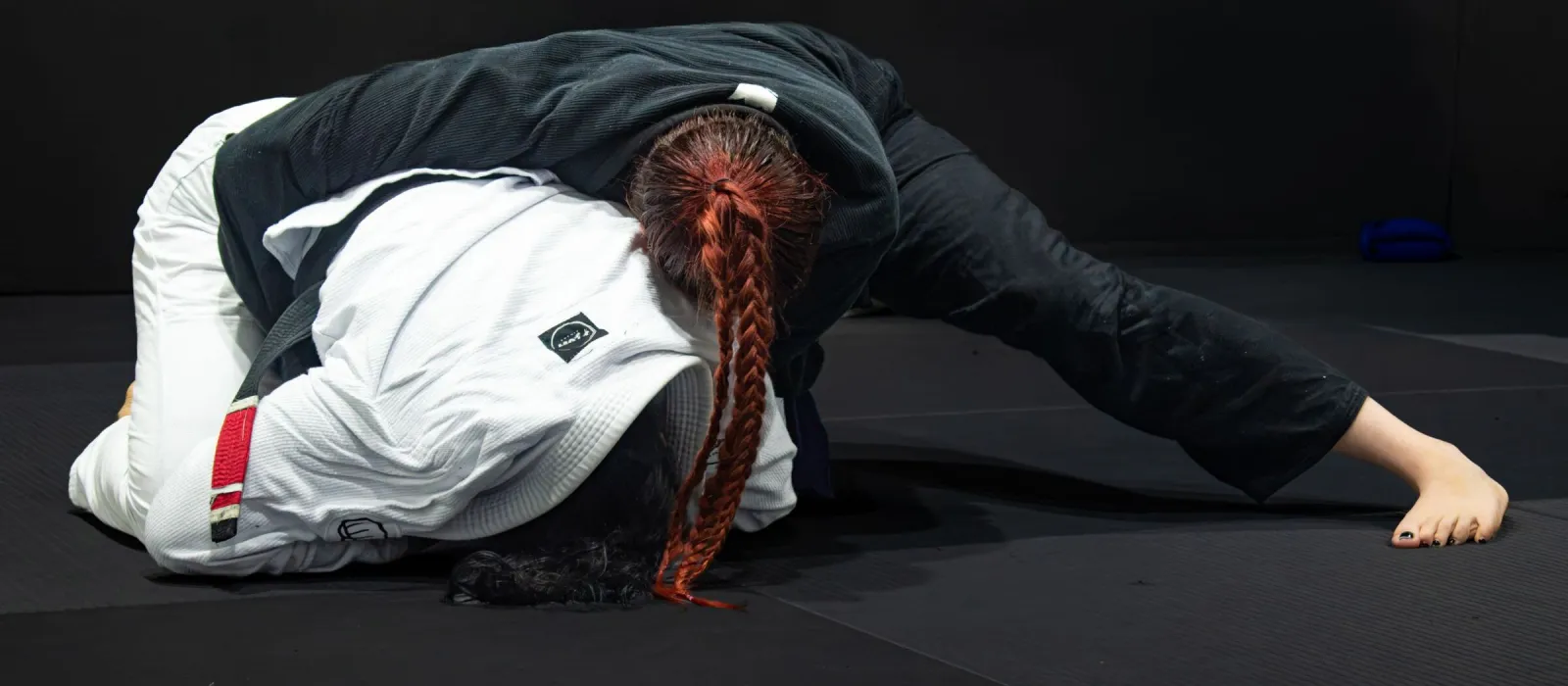 Two grapplers rolling on the mats